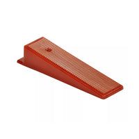 The RAIMONDI 180CUNEO500 RLS Level Wedges (500-Pack) by RAIMONDI are red plastic devices with a ribbed surface, designed to hold doors open and resembling tile leveling system tools, shown at an angle against a white background.